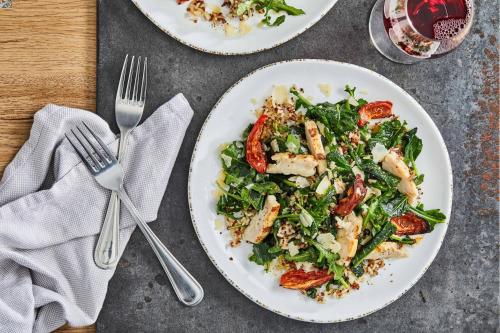 a table topped with plates of food with a salad at Courtyard Salina in Salina