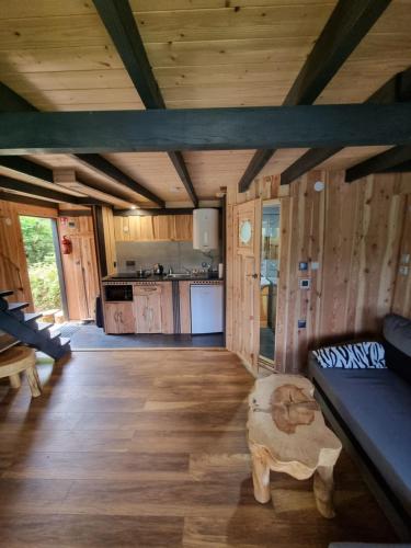 una sala de estar con sofá y mesa en una cabaña en Domki nad Sanem en Lesko