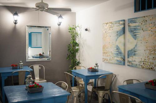 a restaurant with two blue tables and a mirror at Hotel ADAZ Mediterráneo in Santa Marta