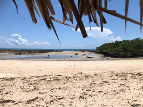 a beach with a person in the water at Porini House in Dar es Salaam