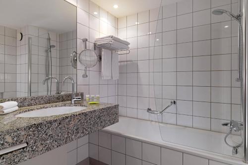 a bathroom with a sink and a shower at Courtyard by Marriott Duesseldorf Hafen in Düsseldorf