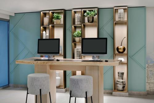 a desk with two computer monitors on top of it at Delta Hotels by Marriott Dubai Investment Park in Dubai