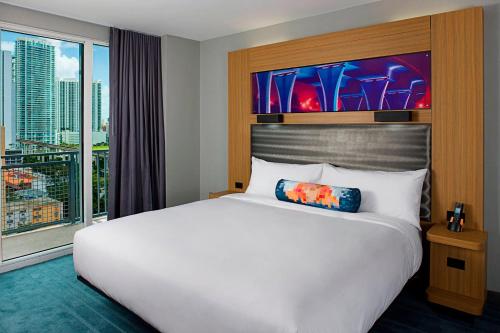 a bedroom with a large bed and a large window at Aloft Miami Brickell in Miami