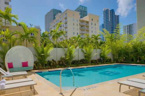 einen Pool mit Palmen und Gebäuden in der Unterkunft Aloft Miami Brickell in Miami