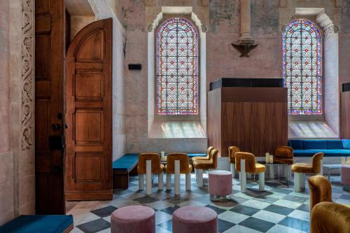 a room with chairs and a door and stained glass windows at The Jaffa - Fattal Limited Edition in Tel Aviv