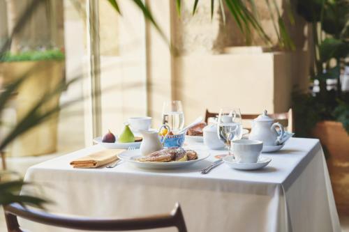 a white table with plates of food on it at The Jaffa - Fattal Limited Edition in Tel Aviv