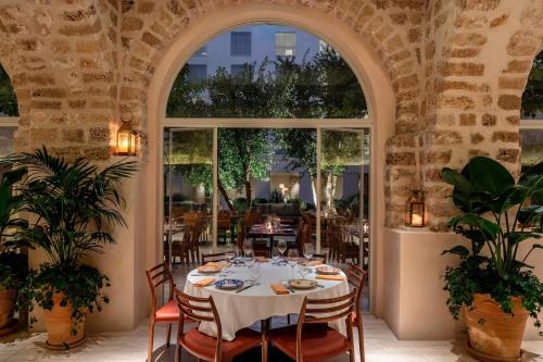 a dining room with a table and a large window at The Jaffa - Fattal Limited Edition in Tel Aviv