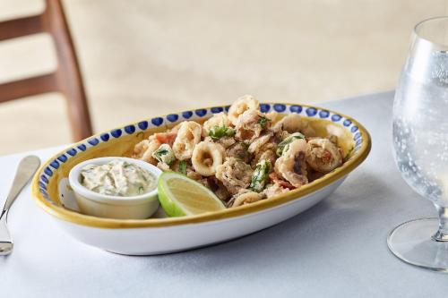 a bowl of shrimp with a lemon and a dip at The Jaffa - Fattal Limited Edition in Tel Aviv
