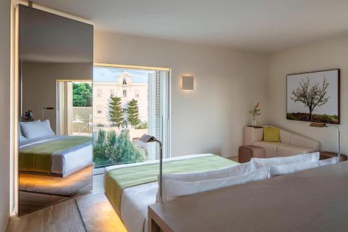 a hotel room with two beds and a window at The Jaffa - Fattal Limited Edition in Tel Aviv