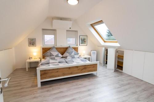 a bedroom with a large bed in a attic at Ferienwohnung zwischen den Wieken in Ostrhauderfehn