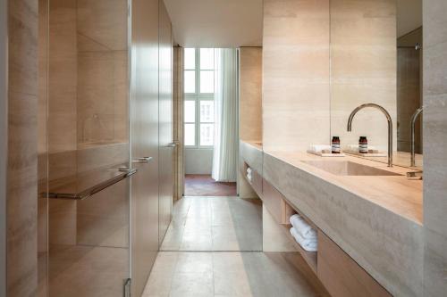 a bathroom with a large sink and a shower at The Jaffa - Fattal Limited Edition in Tel Aviv