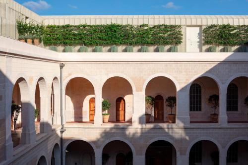 a building with plants on the side of it at The Jaffa - Fattal Limited Edition in Tel Aviv