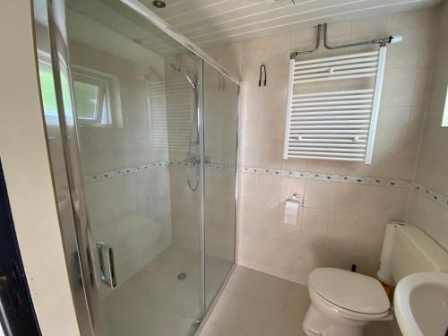 een badkamer met een douche en een toilet bij The island life beach house 2 in De Koog