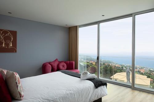 a bedroom with a bed and a large window at King´s View (Heated Pool and Sea View) in Estreito da Calheta