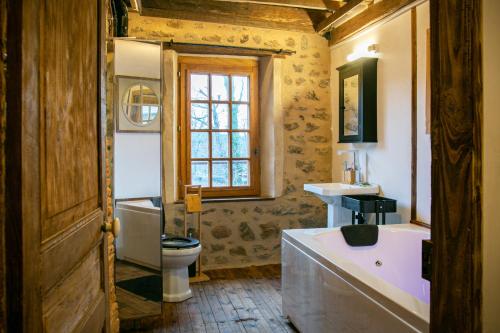 e bagno con vasca, servizi igienici e lavandino. di La Maison du Bonheur & Spa 