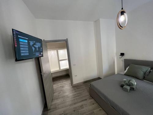 - une chambre avec un lit et une télévision à écran plat dans l'établissement Rooms Via XX Settembre, à Capoterra