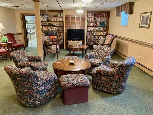 a waiting room with chairs and a table and a tv at Garden Grove Retreat & Lodging near Pictured Rocks, Fayette, Trails in Garden