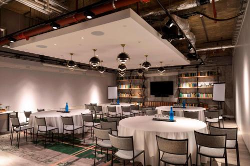 une salle avec des tables et des chaises dans une bibliothèque dans l'établissement Bankside Hotel, Autograph Collection, à Londres