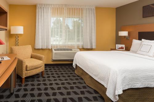 a hotel room with a bed and a chair and a window at TownePlace Suites Old Mill District, Bend Near Mt Bachelor in Bend