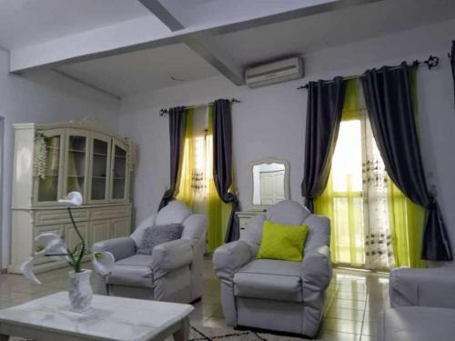 a living room with two chairs and a table at Cybhouse in Yaoundé