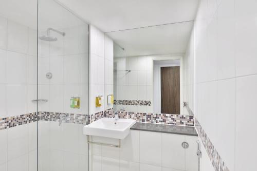 a white bathroom with a sink and a shower at Fairfield by Marriott Goa Anjuna in Anjuna
