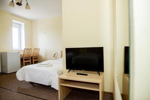 a bedroom with a flat screen tv on a table at Hotel Tomas in Šiauliai