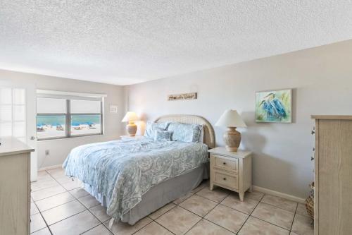 a bedroom with a bed and a view of the ocean at 108 Beach Place Condos in St. Pete Beach