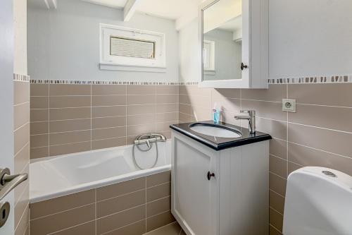 a bathroom with a sink and a bath tub at De Zeevijver Oostduinkerke in Oostduinkerke