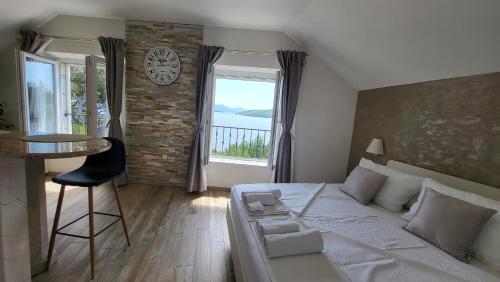 Old Town Sea Front M&M Apartment Korčula في كورتْشولا: غرفة نوم بسرير وطاولة ونافذة