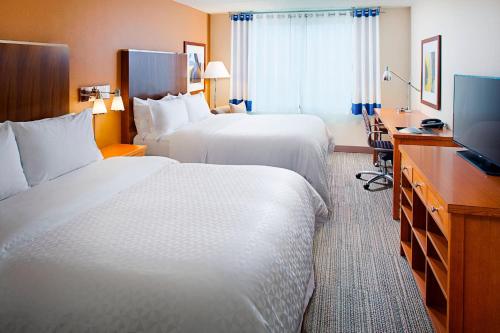 um quarto de hotel com duas camas e uma televisão de ecrã plano em Four Points by Sheraton Philadelphia Airport em Filadélfia