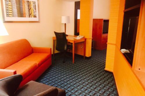 une chambre d'hôtel avec un canapé et un bureau avec un ordinateur dans l'établissement Fairfield Inn and Suites Sacramento Airport Natomas, à Sacramento