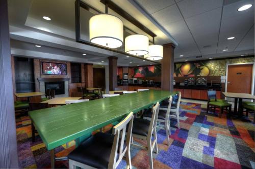 Fairfield Inn and Suites Sacramento Airport Natomas في سكرامنتو: طاولة خضراء كبيرة في مطعم مع كراسي