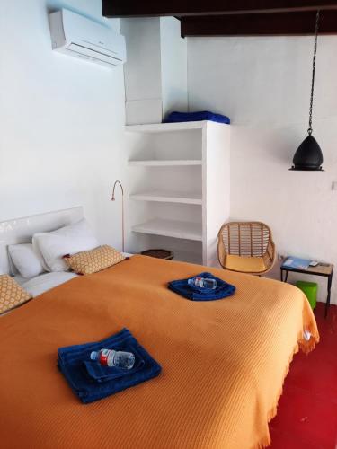 a bedroom with a bed with a orange blanket on it at B&B rural El Oasis in Almuñécar