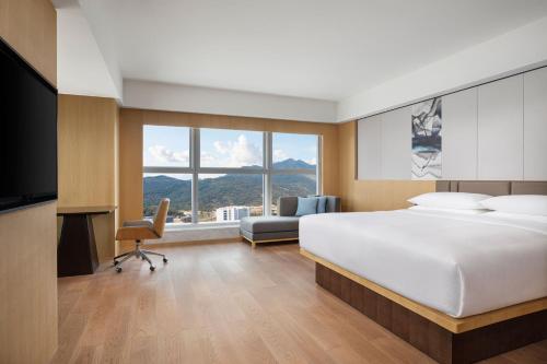 a bedroom with a bed and a couch and a window at Fairfield by Marriott Shenshan Special Cooperation Zone in Haifeng