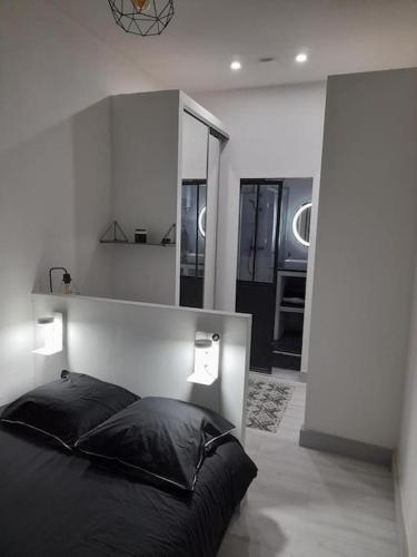 - une chambre avec un lit noir et un miroir dans l'établissement T2 Appartement lumineux à la Joliette, à Marseille