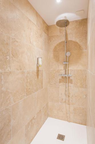a bathroom with a shower with a shower head at Les Pins Blancs en Provence in Le Muy