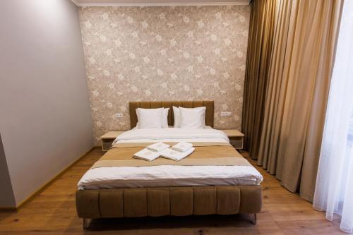 a bedroom with a bed with two books on it at Dream Hotel in Haghpat