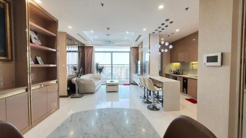 eine Küche und ein Wohnzimmer mit einem Glastisch in der Unterkunft LANDMARK 81 Luxury in Ho-Chi-Minh-Stadt