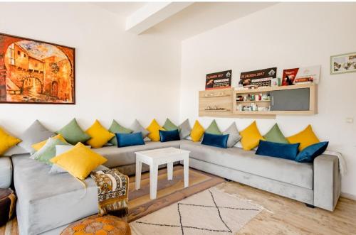 a living room with a couch with blue and yellow pillows at Elaaz Horse Farm in Azemmour