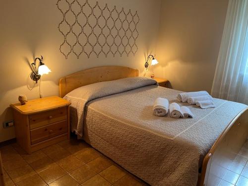 a bedroom with a bed with two towels on it at Residenza La Ciasa in Claut