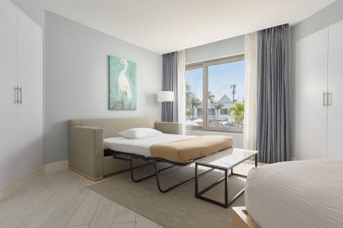 ein Schlafzimmer mit einem Bett und einem großen Fenster in der Unterkunft Courtyard by Marriott Aruba Resort in Palm-Eagle Beach