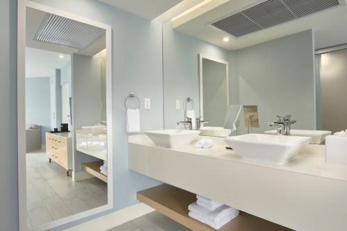 ein Badezimmer mit zwei Waschbecken und einem großen Spiegel in der Unterkunft Courtyard by Marriott Aruba Resort in Palm-Eagle Beach