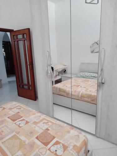um quarto com duas camas e um espelho em La casa di Eleonora em Nápoles