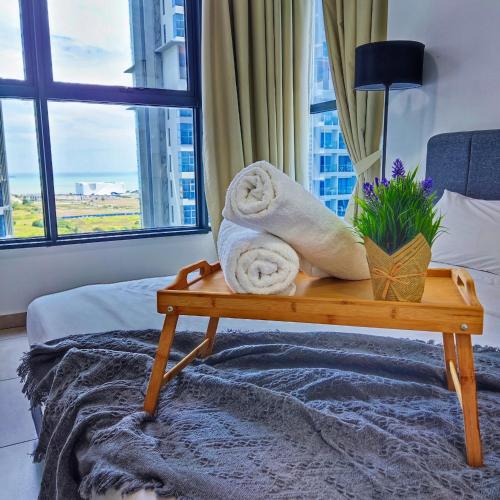 a hotel room with towels on a bed with a window at Atlantis residence #2Bedroom #2-8Pax in Melaka