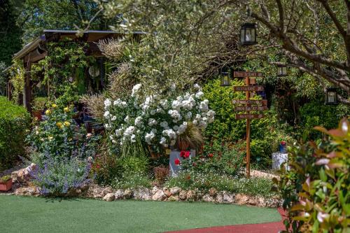 a garden with flowers and a sign in the middle at Les Pins Blancs en Provence in Le Muy