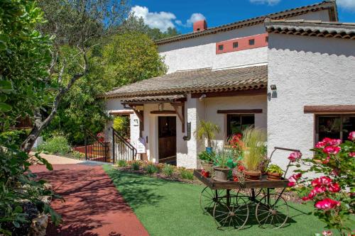 a garden in front of a house with a table with flowers at Les Pins Blancs en Provence in Le Muy