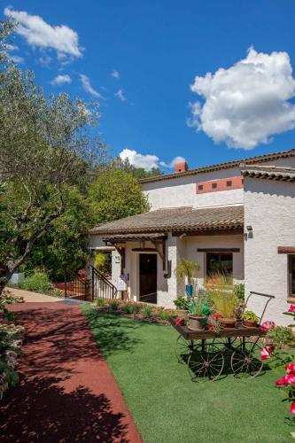 a yard with a table and chairs in front of a house at Les Pins Blancs en Provence in Le Muy
