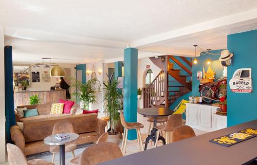 a living room with a couch and a table and chairs at Les Pins Blancs en Provence in Le Muy