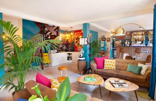 a living room with a couch and some plants at Les Pins Blancs en Provence in Le Muy