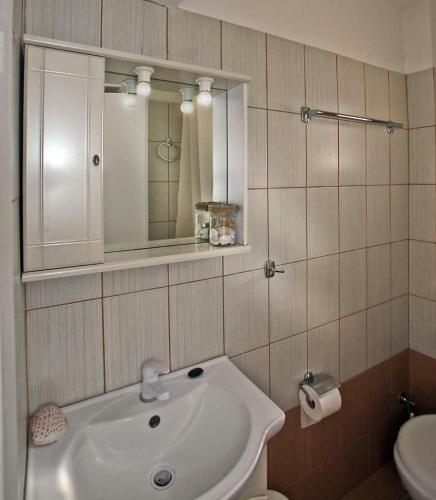 a bathroom with a sink and a mirror and a toilet at Amelia rooms in Batsi